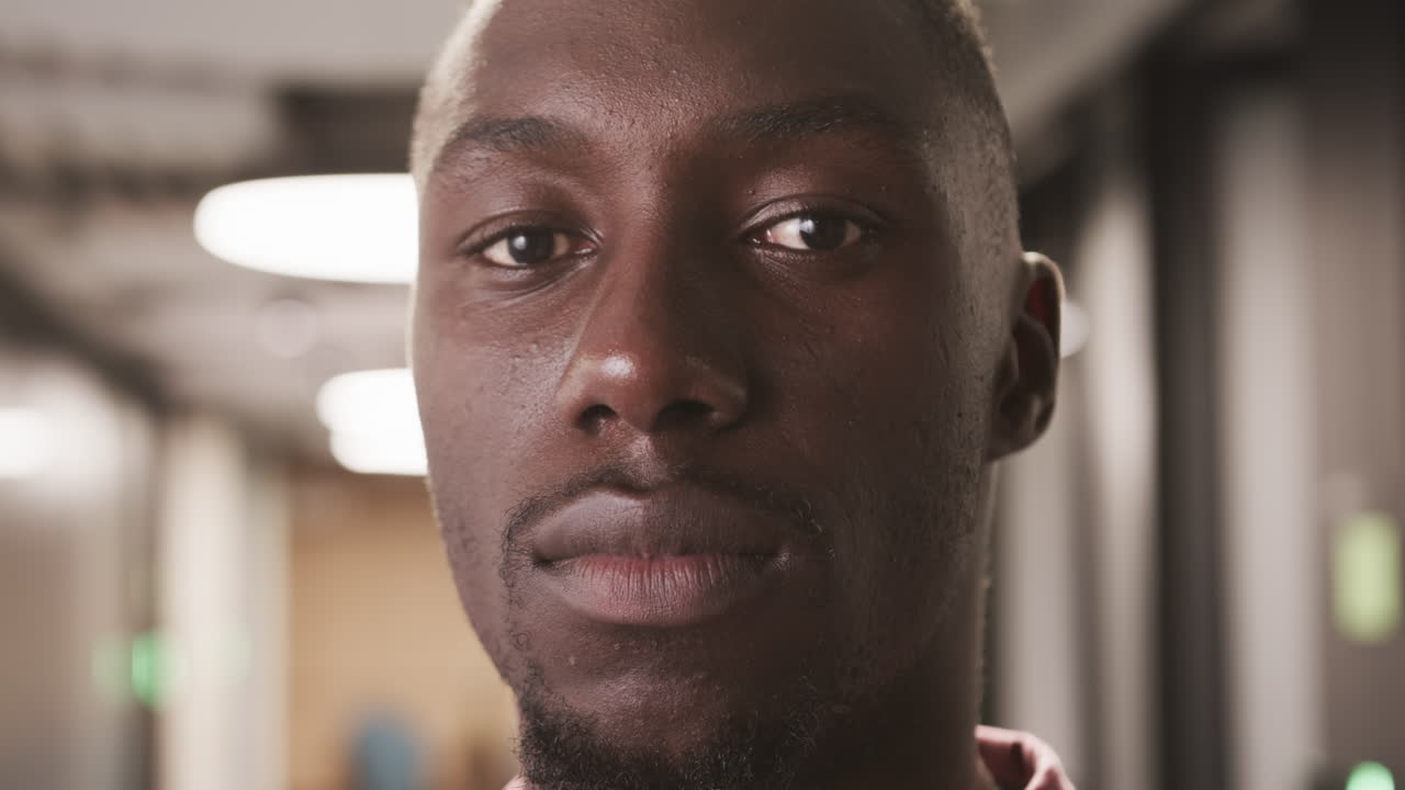Close-up of serious businessman in office hallway, focusing on camera