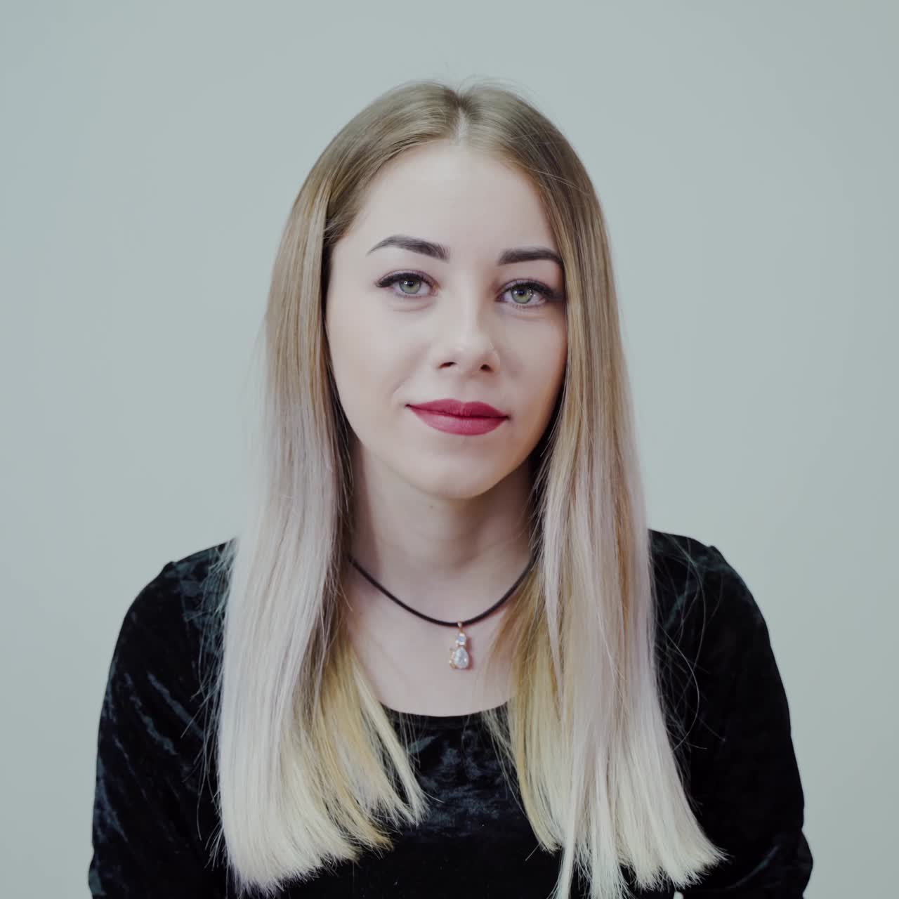 Portrait of a blonde woman with bright lips. Beautiful girl looking at camera and smiling isolated in studio.
