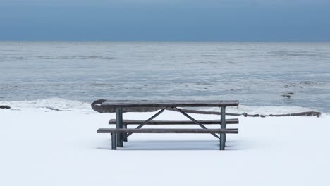 wide shot of a picnic table on a snowy beach