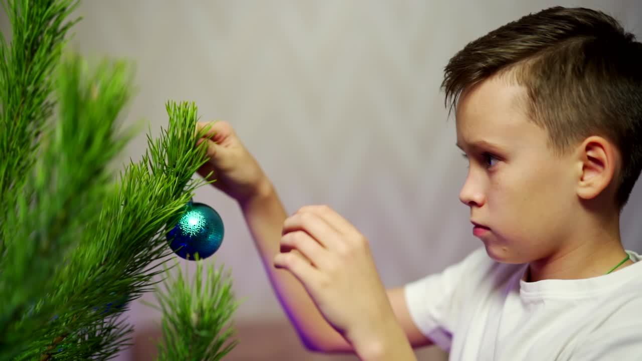 Kid decorating Christmas tree. Portrait of boy decorating Christmas tree