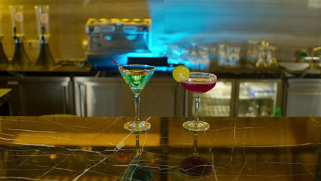 hand of woman leaving her drink on bar counter next to her partner's