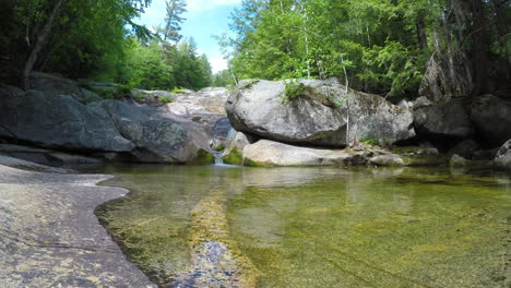 4k-stationary-shot-Maine-forest-wilderness-Stepp-Falls-Hiking-trail-area-filled-with-cascades-and-waterfalls-with-large-crystal-clear-pools-of-water-for-swimming