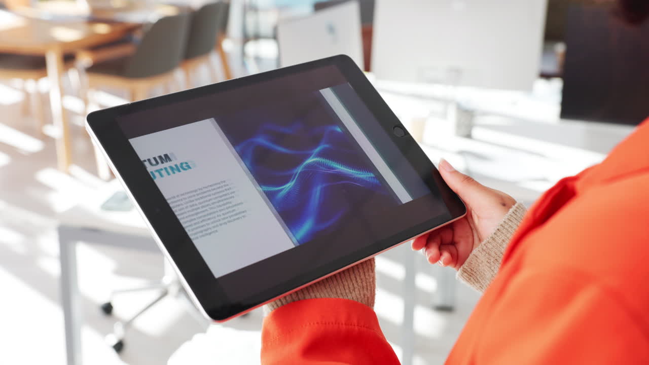 Person reviewing quantum computing presentation on tablet in an office setting