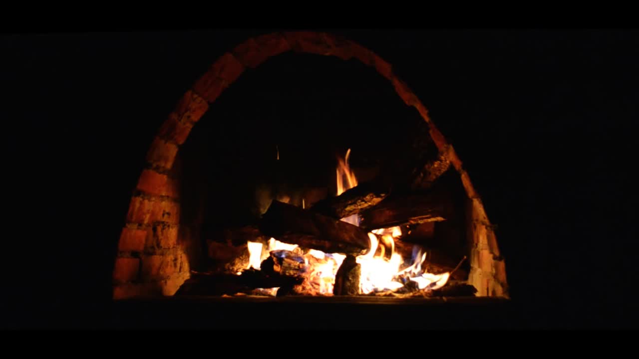 내부에 장작이 타고 있는 꾸준한 캠 아치 모양의 벽돌 벽난로, 정면도