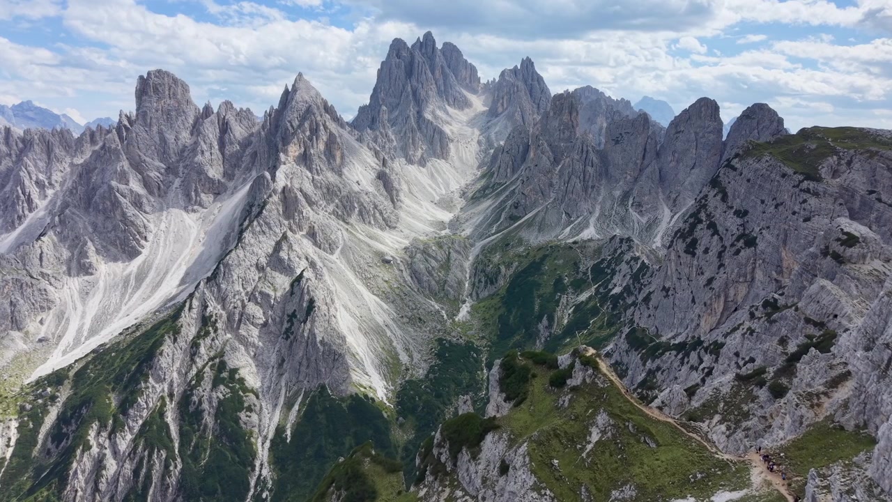 Veduta aerea con drone attraverso la spettacolare catena dei Cadini di Misurina, che rivela imponenti guglie calcaree, gole erose, ripidi ghiaioni e vegetazione alpina