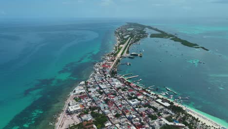 vista aérea de la ciudad en la isla de isla mujeres en el soleado méxico - levantamiento, retroceso, disparo de drones