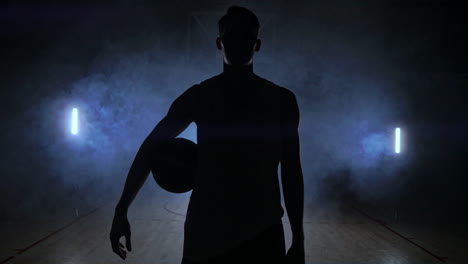 Basketballspieler-Schlägt-Den-Ball-Im-Licht-Der-Hinter-Den-Tribünen-Der-Duma-Leuchtenden-Lampen-Und-Wirft-Den-Ball-In-Zeitlupe-Auf-Den-Boden-In-Der-Basketballhalle