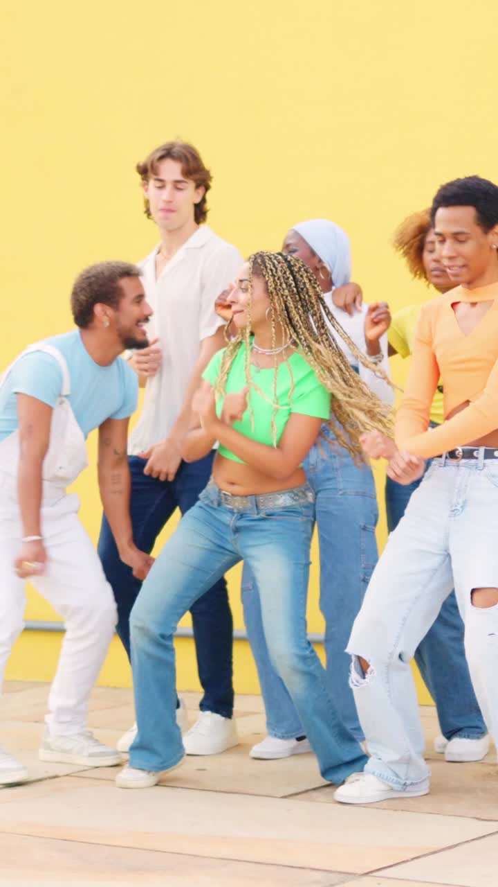 Multicultural friends dancing in an urban square