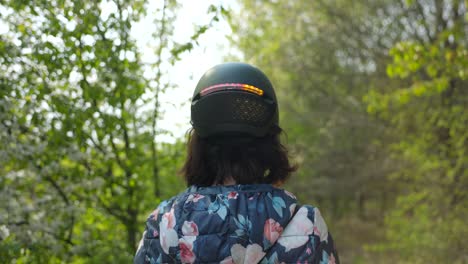 Vista-Detrás-De-Una-Mujer-Al-Aire-Libre-Con-Casco-Inteligente-Con-Luz-Trasera