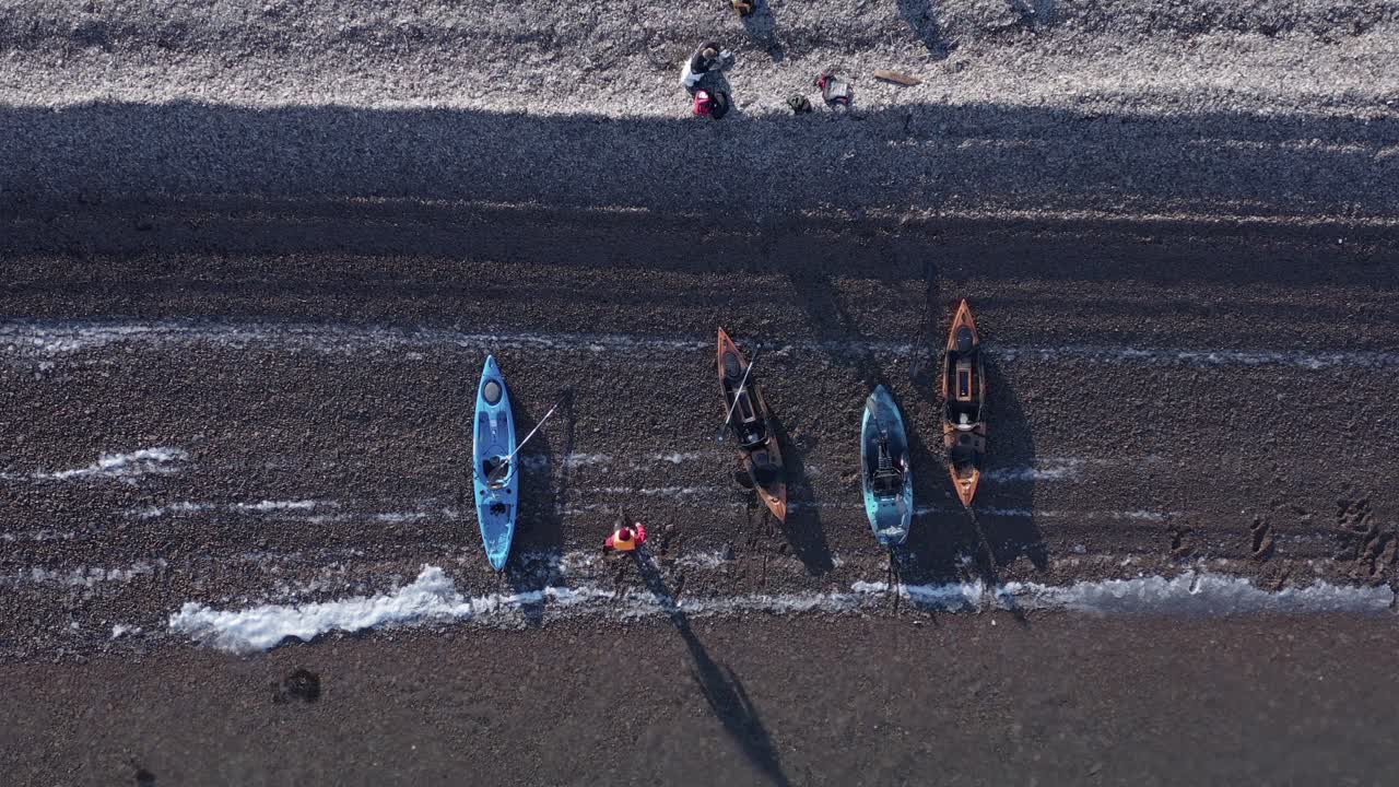 아이슬란드의 자갈 해변에서 쉬고 있는 카약 그룹의 하향식, 공중