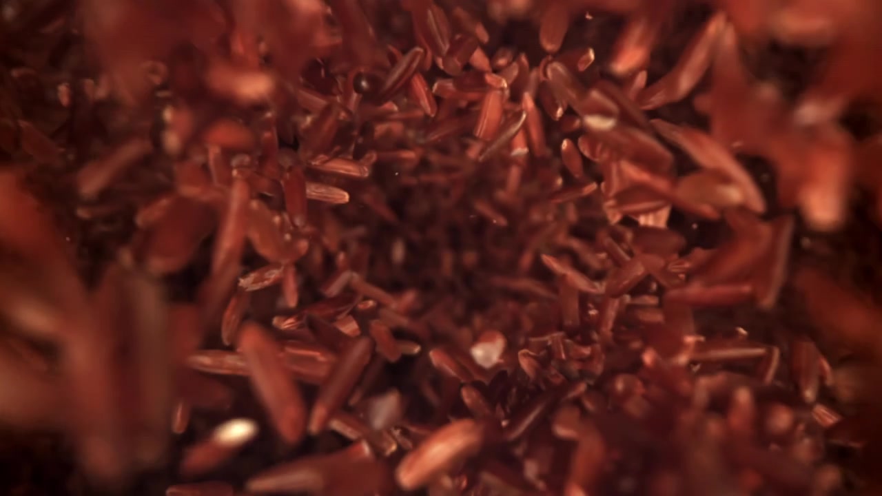 Grãos de Arroz Vermelho Caindo e Rodopiando em Câmera Lenta.