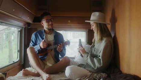 couple enjoying music and a selfie in a campervan