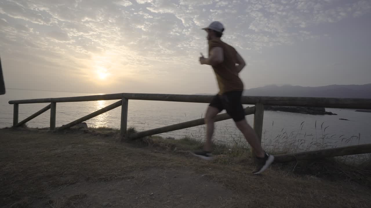 hombre corriendo en la naturaleza, océano al fondo, amanecer, día nublado, tiro estático