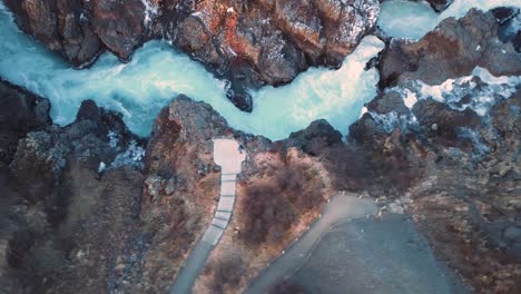 Drone-with-cinematic-movements-shows-beautiful-icelandic-waterfall,-Hraunfossar,-in-sunset-light-from-multiple-angles