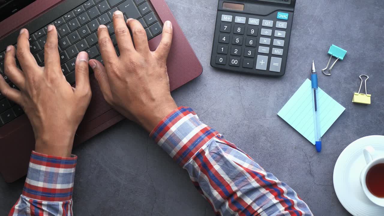 persona escribiendo en una computadora portátil en un escritorio
