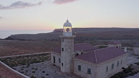 Aerial-pull-back-reveal-of-quaint,-remote-Punta-Nati-Lighthouse-in-Spain