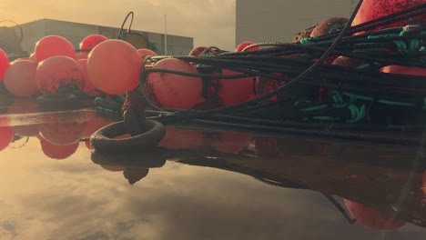 las boyas rojas brillantes adornan los muelles de un pintoresco pueblo pesquero español, firmemente anclado a lo largo del muelle costero, ofreciendo un vistazo al encanto de este acogedor puerto y su población pesquera.