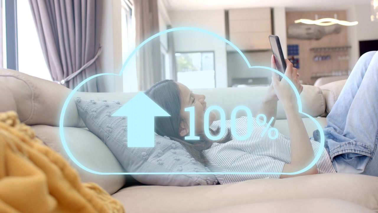 Kvinde ligger på sofaen og bruger sin telefon, mens en sky over hendes overkrop viser en uploadprocent på 100%.