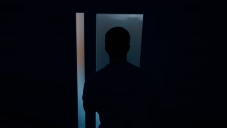 male silhouette near the door to a delivery room. worried husband waiting for his wife giving birth to a child.