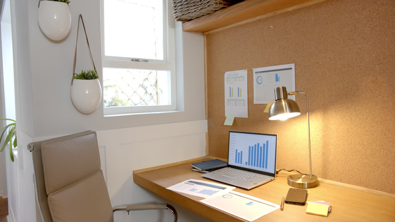 Analyzing data on laptop, charts and graphs on desk in home office, copy space