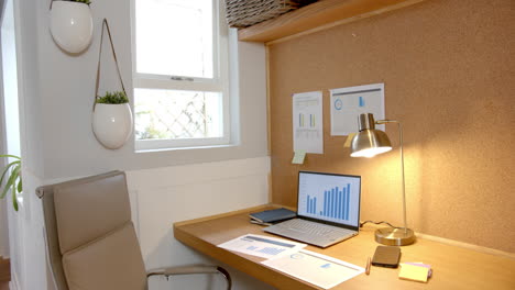 analyzing data on laptop, charts and graphs on desk in home office, copy space