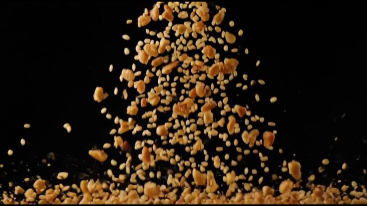 Peanuts and Sesame Seeds Falling Against a Black Background
