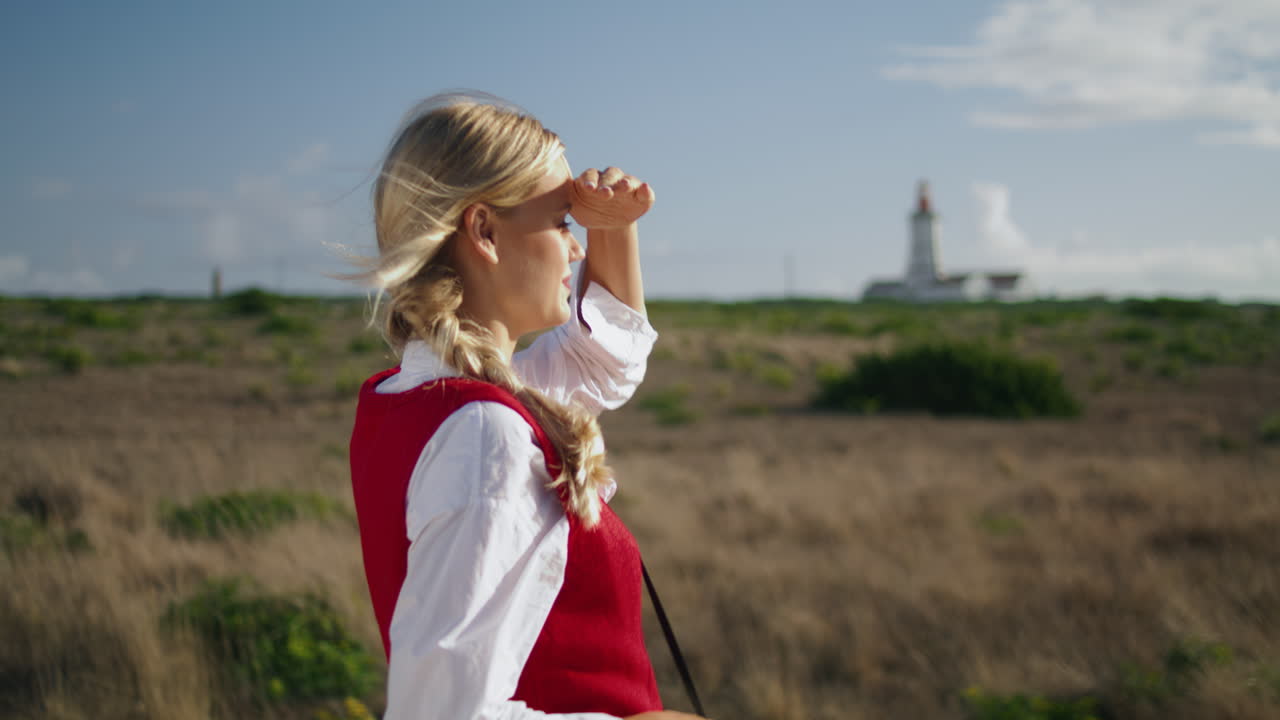 영감을 받은 여성이 필드 클로즈업으로 걸어가고 있다. 수직 촬영 여성이 디지털 카메라를 들고 있다.