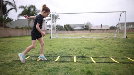 a young athletic girl does her workout at the park as she performs the mickey shuffle on a speed ladder