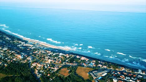 Drone-Volando-Sobre-Algunas-Casas-Residenciales-Y-Una-Escuela-Primaria-Con-Vistas-Al-Mar-Al-Fondo-En-La-Playa-De-Brighton