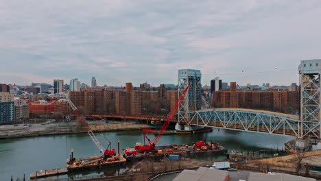 slow push with 4k drone of bridge, east river, in new york city, buildings in background