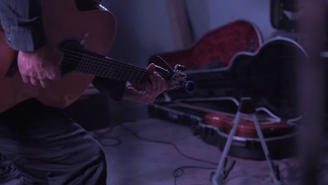 Musician-stands-up-with-guitar-on-stage-slow-motion-dramatic-close-up