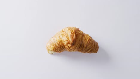 Video-of-close-up-of-croissant-with-copy-space-on-white-background