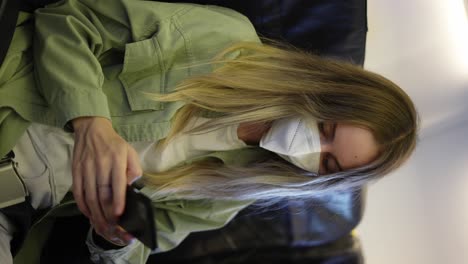 woman travel tourist in white respirator using mobile at the airplane