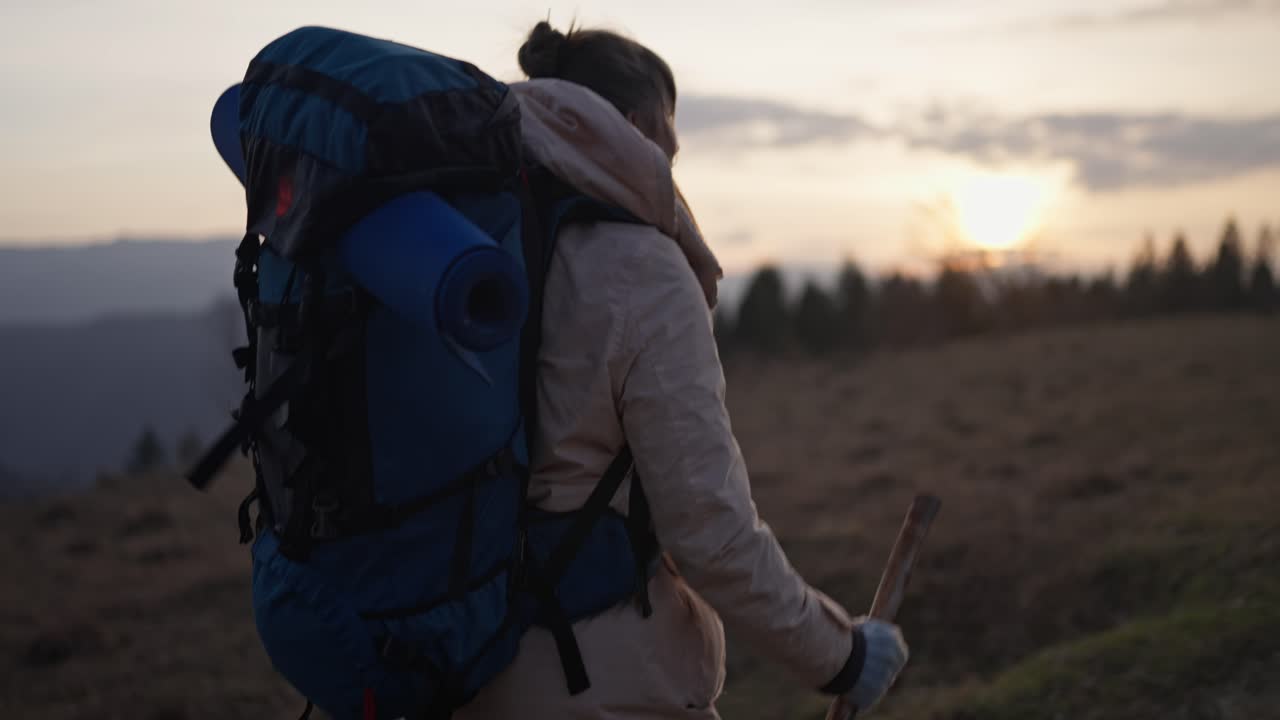 Woman Hiking in the Mountains at Sunset