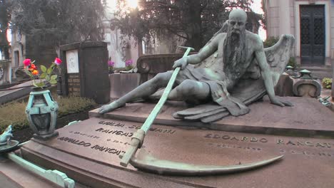 el ángel de la muerte se sienta en una tumba en un cementerio con su guadaña 2