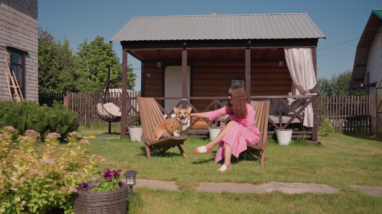 Peaceful Outdoor Bonding, Calm Moment With Dog Outside, Relaxed Lady Shares Tranquil Time With Corgi Outdoors, Gentle Petting And Quiet Companionship Between Woman And Corgi On Sunny Porch
