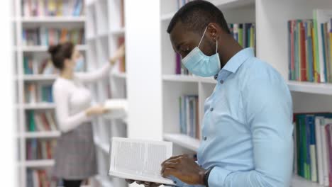 student reading in a library during a pandemic.