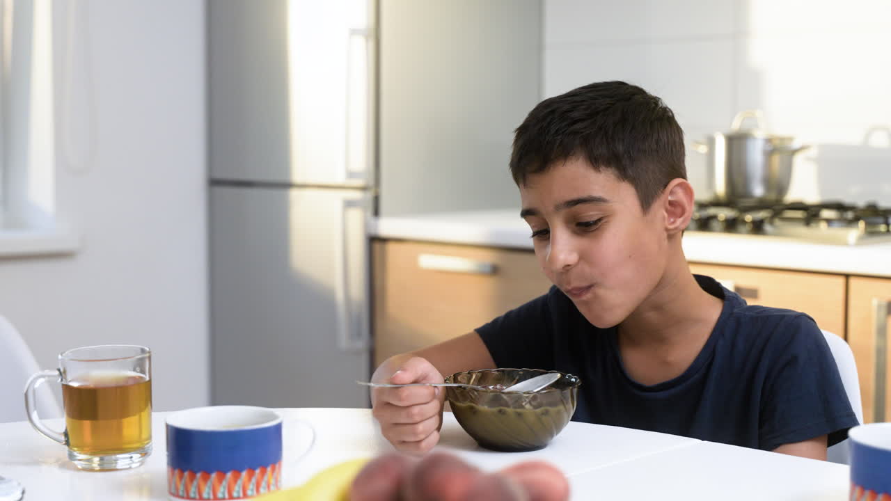 una vista de cerca de un niño islámico tomando el desayuno.