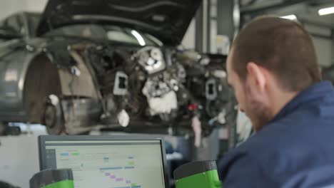 mechanic repairing car engine in auto workshop