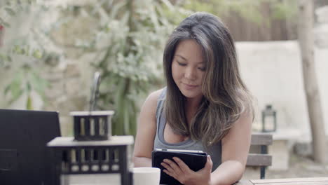 Cámara-Lenta-De-Una-Mujer-Japonesa-Mirando-La-Pantalla-De-La-Tableta-Al-Aire-Libre