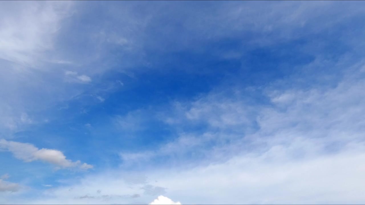 Timelapse di nuvole cumulo bianche che si muovono in un cielo azzurro brillante, catturando il movimento naturale del tempo e un paesaggio atmosferico sereno.