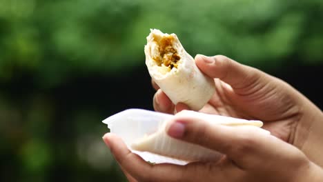 Mano-De-Mujer-Comiendo-Pollo-Al-Aire-Libre,