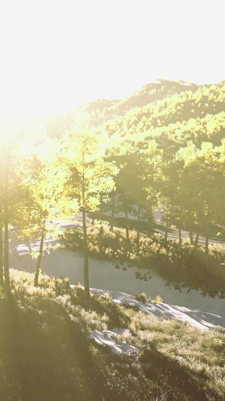 Sunlit river winding through vibrant green hills in a tranquil outdoor setting