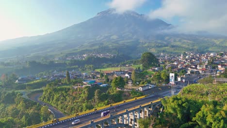 sigandul bridge with mount sumbing in the background on a clear sunny day, aerial view