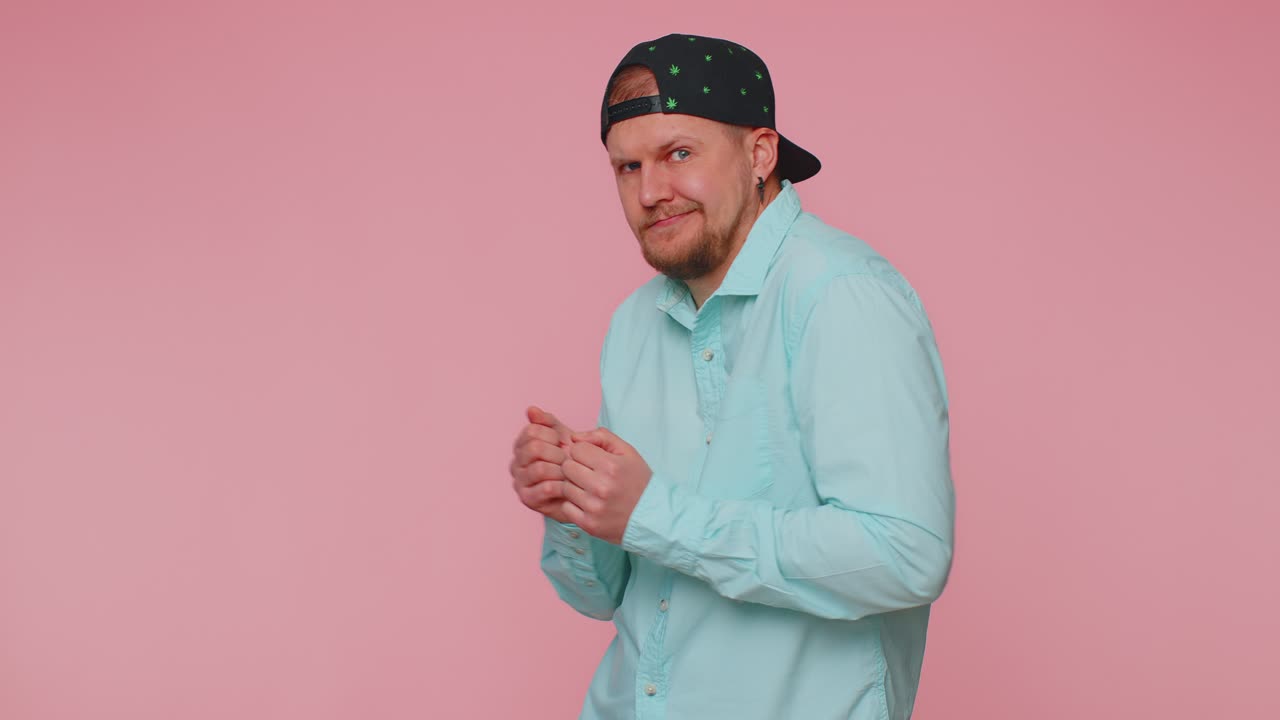 Uomo divertente che ascolta musica, sorride e balla al ritmo di una festa disco, muovendo ritmicamente le sopracciglia e divertendosi.