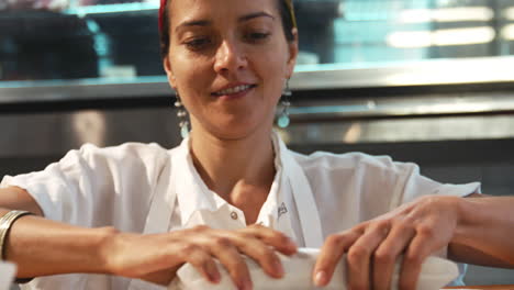 mujer joven envolviendo comida para llevar en una delicatessen, café, de cerca