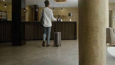 woman checking in at the hotel reception desk