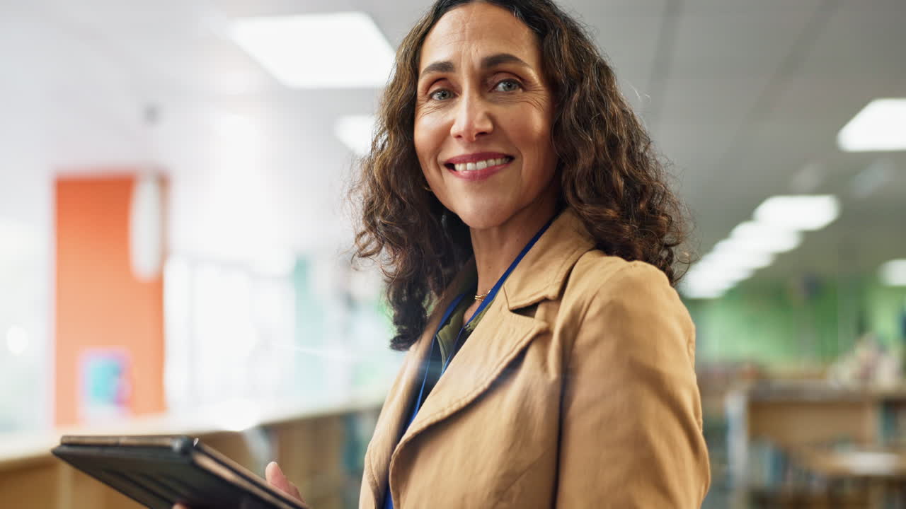 Portrait of a teacher with a tablet in a library