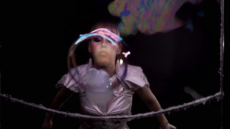 Close-up-Cute-girl-does-tricks-with-soap-bubbles-She-blows-a-bubble-from-her-hand-towards-the-viewer