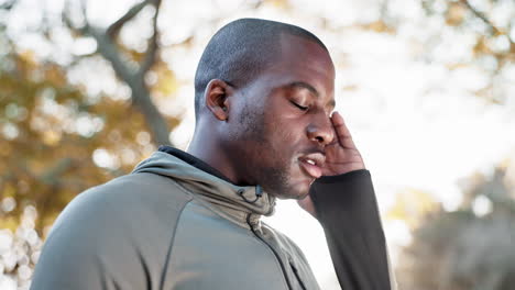 Black-man,-headache-and-pain-with-fitness-in-park